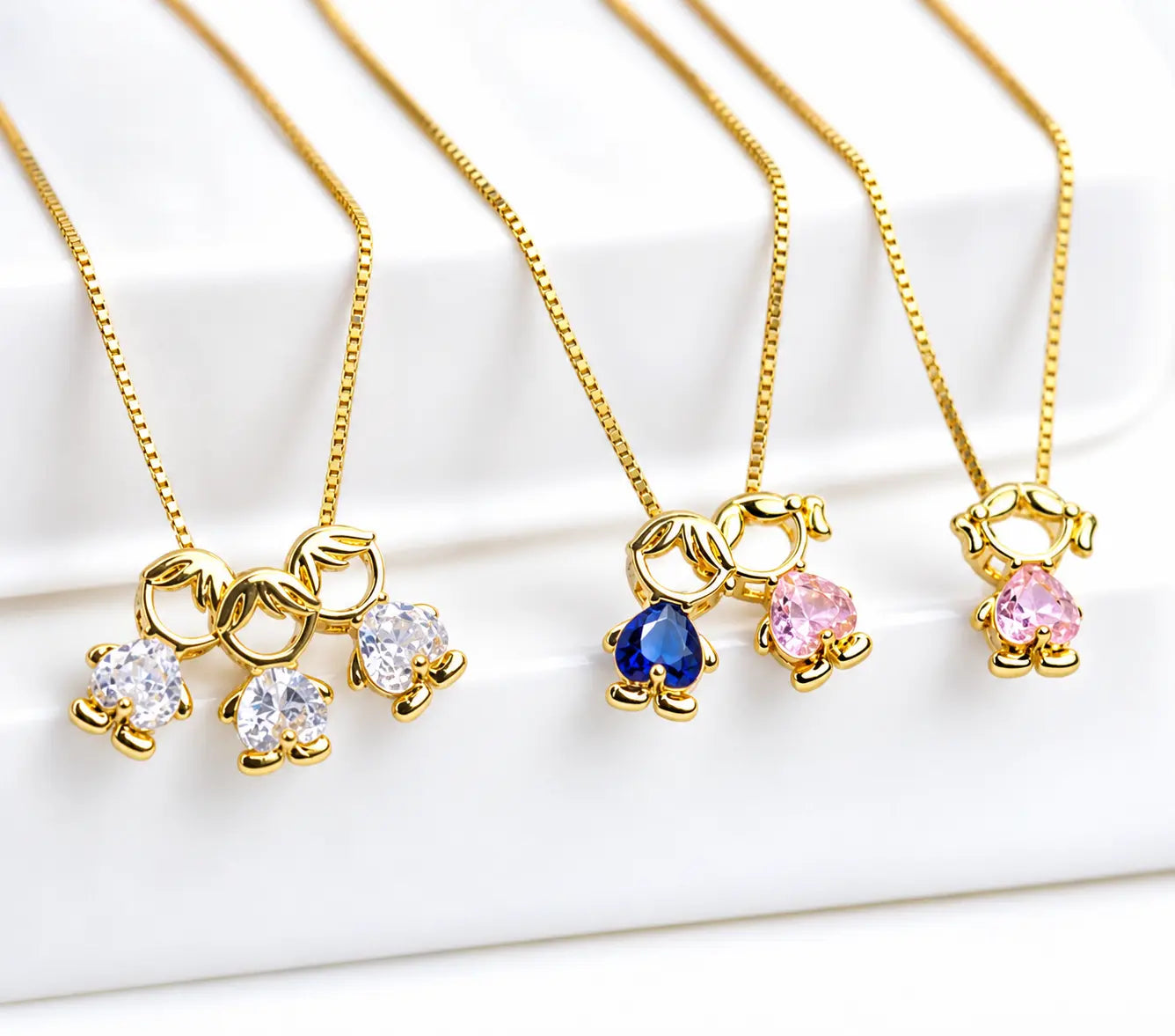 Mother & Child Love Necklace in gold tone, shown with child figure pendants in white, pink and blue stones