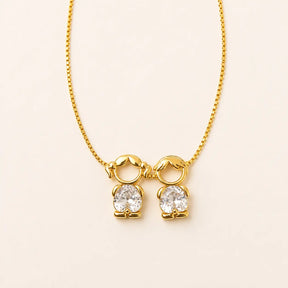 Gold-tone necklace with a girl and a boy figure pendant in white stones