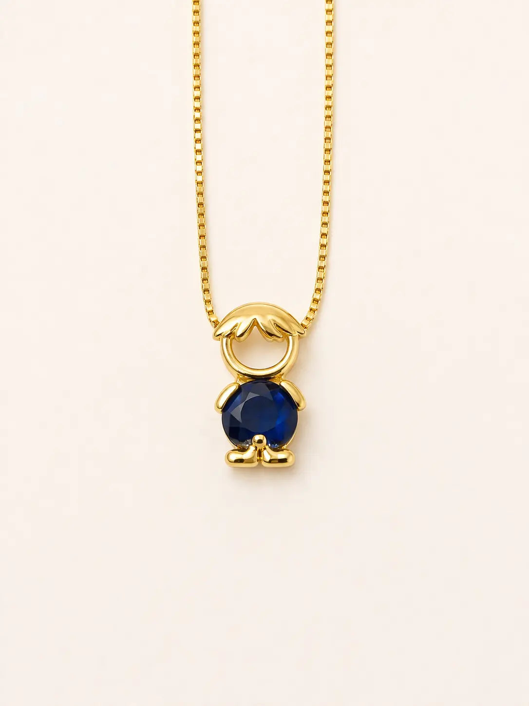 Gold-tone necklace with one boy figure pendant and a blue stone