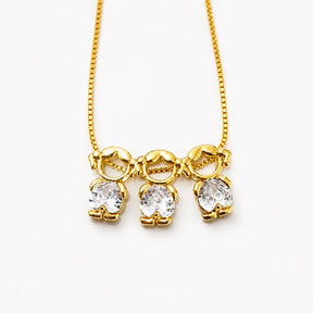 Gold-tone necklace with three girl figure pendants and white stones