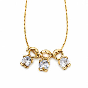 Gold-tone necklace with one girl and two boy figure pendants in white stones
