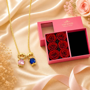 Mother & Child Love Necklace with pink and blue stones next to the luxury gift box with red roses