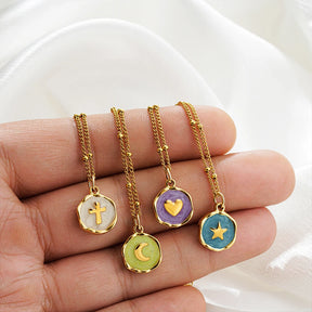 Four Celeste Talisman pendants held in hand to show their dainty size